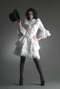 Western woman in white lacy dress with black top hat give a 'strong' pose with a confident expression.