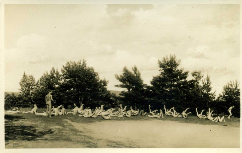 Black and white photograph of nudists exercising outdoors at nudist camp in Berlin