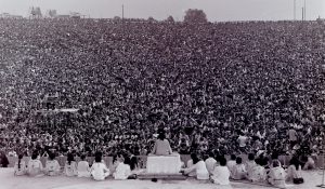 Black and white photo of a packed audience at the opening ceremony of Woodstock