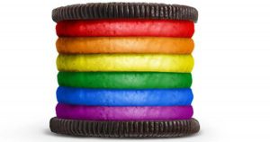 An oreo with 6 layers of frosting, each layer a color of the rainbow, together resembling the gay pride flag between two Oreo cookies.