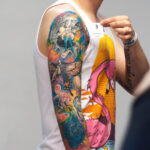 Profile view of a man's arm, showing off his colorful sleeve of tattoos.