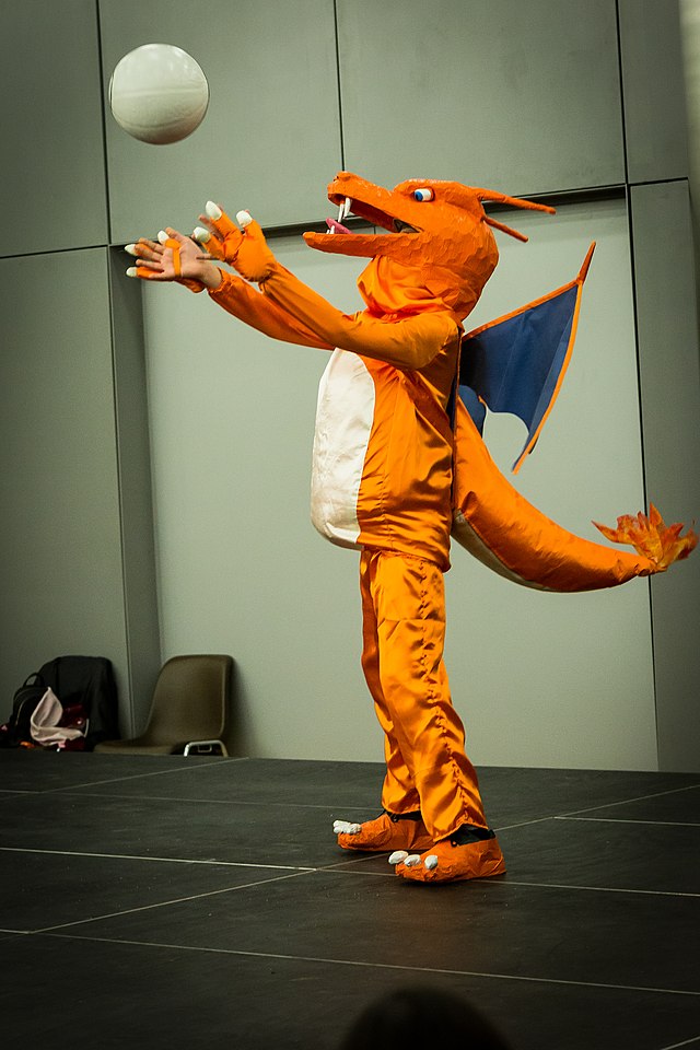 Man dressed as Charizard from Pokemon throwing a ball into the air.