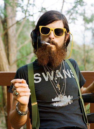 A stereotypical hipster, scraggly beard bold frame glasses and a graphic tee