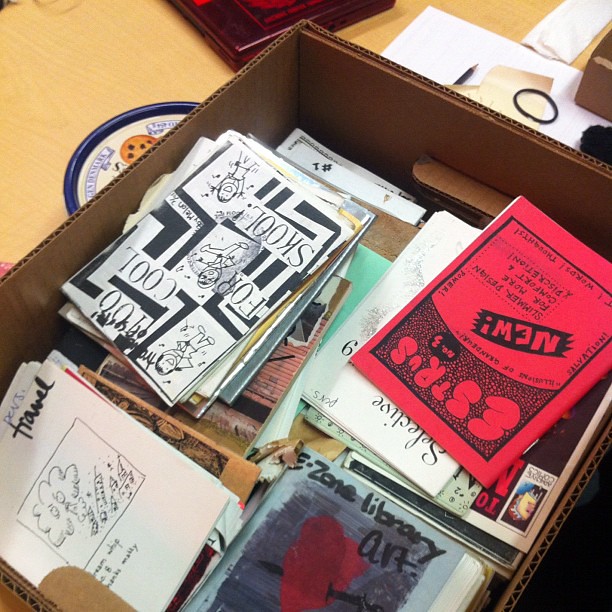 A box of printed zines from the 1990s.